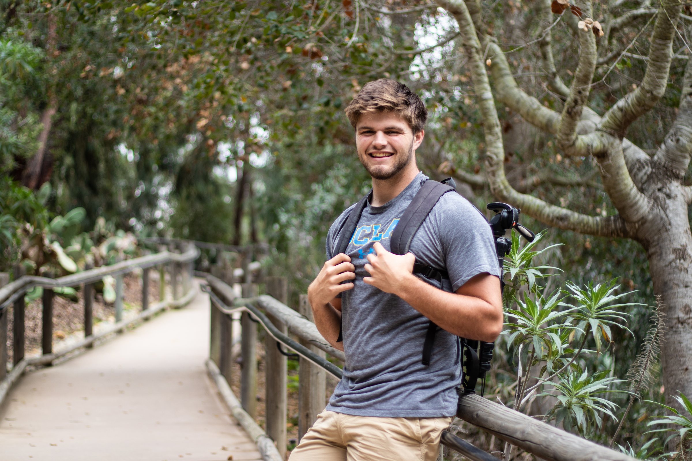 Jay Furubotten, San Diego wedding, engagement, and sports photographer, on a garden path with his camera pack