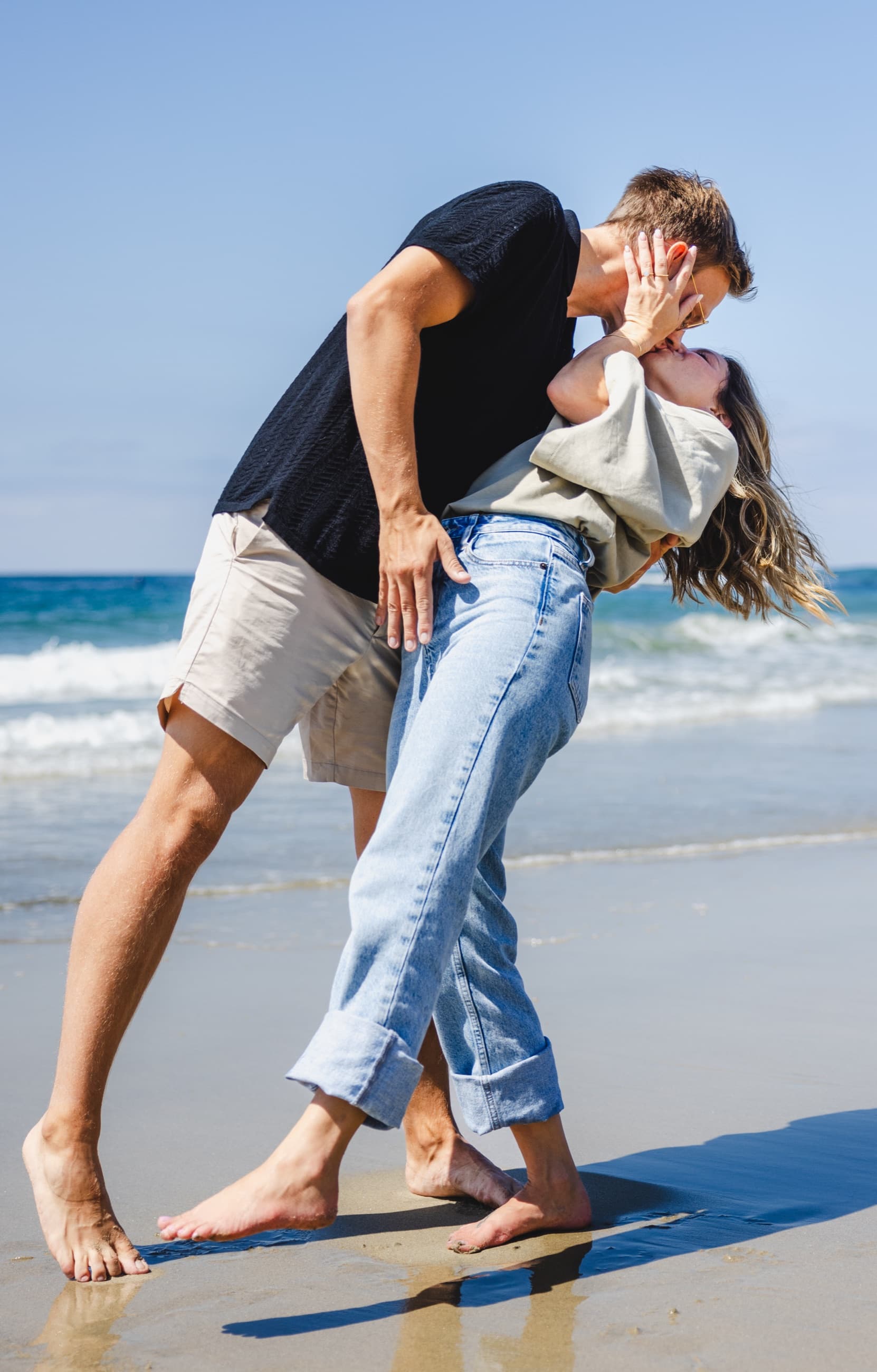 Couple dipping into a kiss on the shore